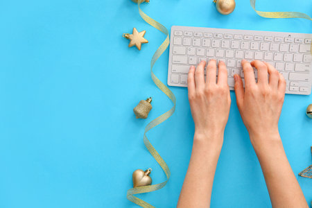 Hands with PC keyboard and New Year decor on color backgroundの写真素材