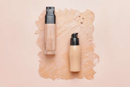 Bottles of makeup foundation and samples on color backgroundの写真素材