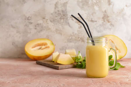 Mason jar with melon smoothie on color backgroundの写真素材