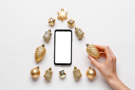 Hand and New Year composition with mobile phone on light backgroundの写真素材