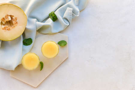 Glasses with melon smoothie on light backgroundの写真素材