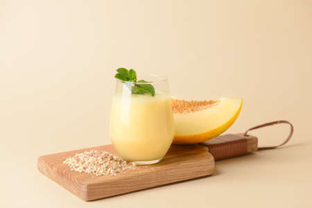 Glass with melon smoothie on color backgroundの写真素材
