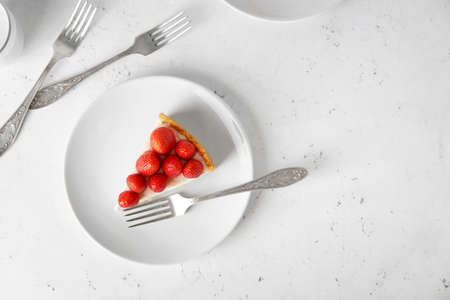 Plate with tasty strawberry cheesecake on tableの写真素材