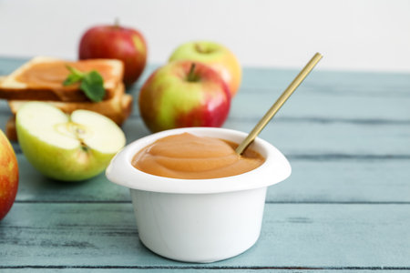 Bowl with sweet apple jam on color wooden backgroundの写真素材