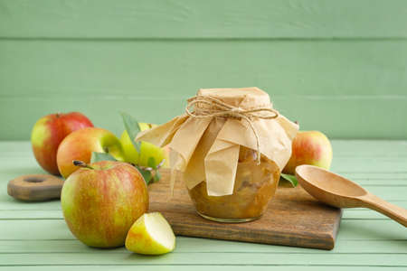 Jar with sweet apple jam on color wooden backgroundの写真素材