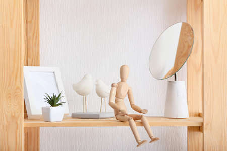 Wooden mannequin on shelf in room