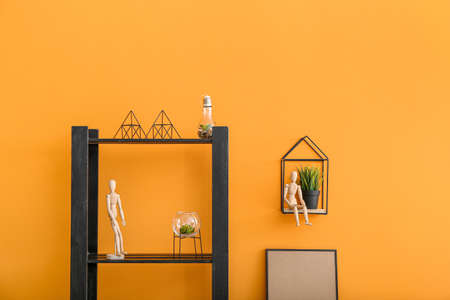 Rack with stylish decor near color wall in roomの写真素材