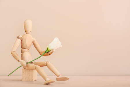 Wooden mannequin with flower on color backgroundの写真素材