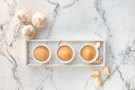 Bowls with aromatic powdered garlic on white backgroundの写真素材