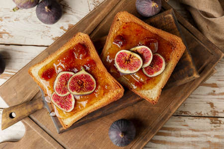 Tasty toasted bread with sweet fig jam on tableの写真素材