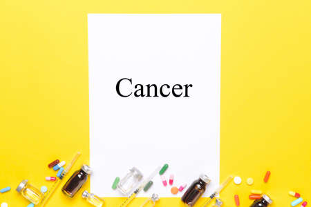 Paper sheet with word CANCER and medications on color backgroundの写真素材