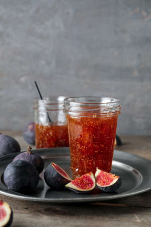 Jar of sweet fig jam on wooden tableの写真素材