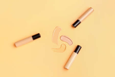 Bottles of makeup foundation and samples on color backgroundの写真素材