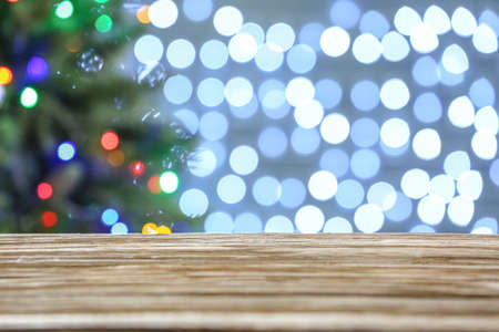 Empty wooden table against blurred Christmas lights
