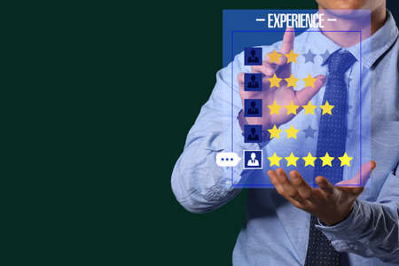 Businessman giving rating to new computer application on dark backgroundの写真素材