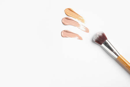 Samples of makeup foundation and brush on white backgroundの写真素材