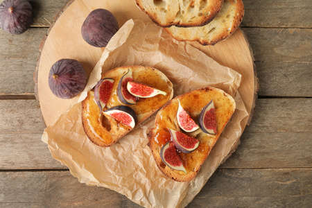 Tasty sandwiches with sweet fig jam on table