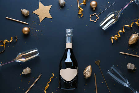 New Year composition with bottle of champagne on dark background