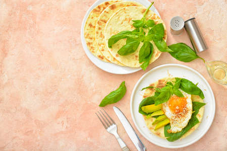 Tasty fried egg with avocado and flatbread on color backgroundの写真素材