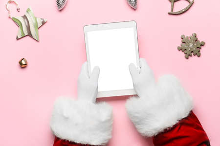 Santa Claus with tablet computer on color background, top viewの写真素材