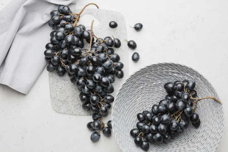 Bowl with sweet ripe grapes on table