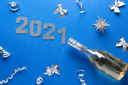 New Year composition with bottle of champagne on color background