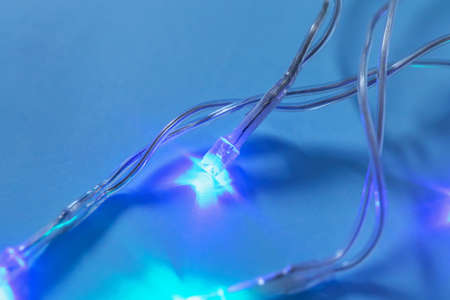 Glowing Christmas lights on color background