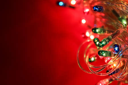 Glowing Christmas lights on color backgroundの写真素材