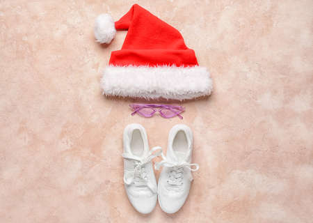 Santa hat with eyeglasses and shoes on color backgroundの写真素材