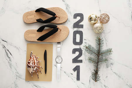 New Year composition with decor, notebook and flip-flops on white background