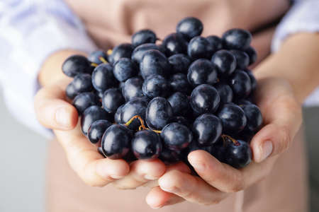 Woman with fresh grapes, closeup