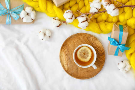 Cup of tea with gift boxes on bedの写真素材