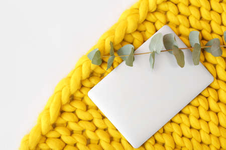 Laptop and knitted plaid on white backgroundの写真素材