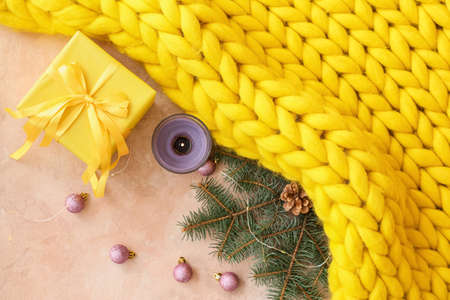 Christmas composition with knitted plaid and gift box on color backgroundの写真素材