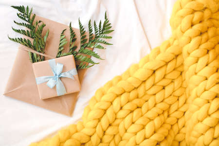 Gifts with knitted plaid on bedの写真素材