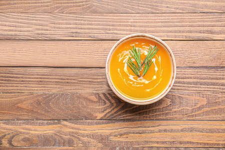 Tasty pumpkin cream soup in bowl on tableの写真素材