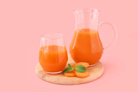 Board with tasty carrot juice on color backgroundの写真素材