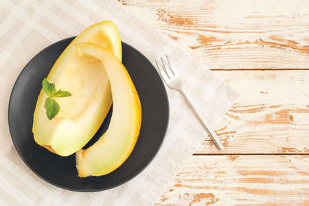 Plate with sweet cut melon on wooden backgroundの写真素材