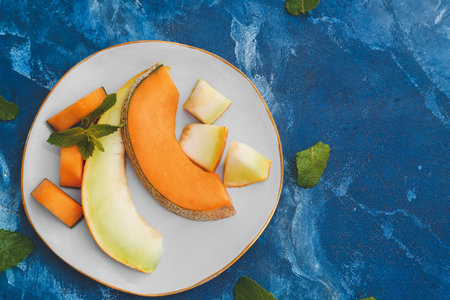 Plate with sweet cut melon on color backgroundの写真素材