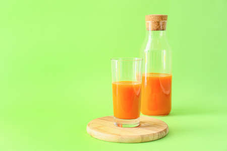 Glass of tasty carrot juice on color backgroundの写真素材