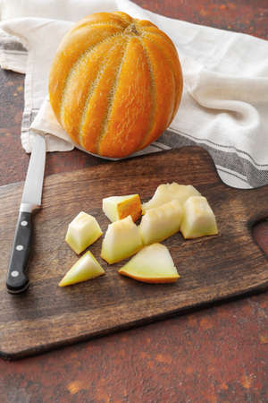 Board with sweet cut melon on grunge background