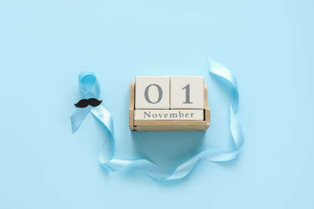 Calendar with blue ribbon and mustache on color background. Prostate cancer awareness conceptの写真素材