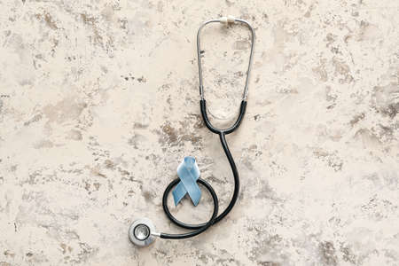 Blue ribbon and stethoscope on gray background. Prostate cancer awareness concept