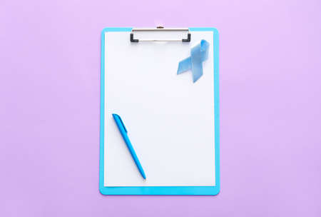 Blue ribbon and clipboard on color background. Prostate cancer awareness conceptの写真素材