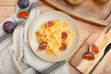 Plate of tasty pancakes and figs on wooden backgroundの写真素材
