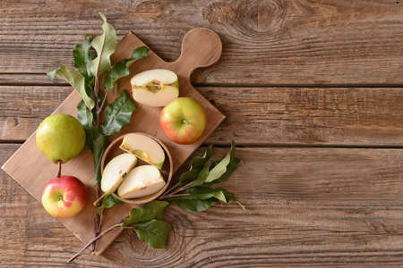 Board with tasty apple and pear fruits on tableの写真素材
