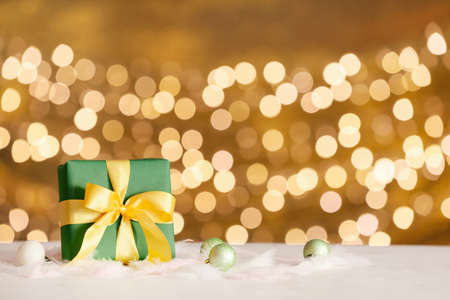 Christmas decor with gift box on table against blurred lights