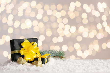 Christmas decor with gift boxes on table against blurred lights