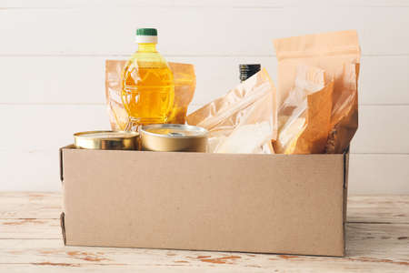 Box with different products on wooden background
