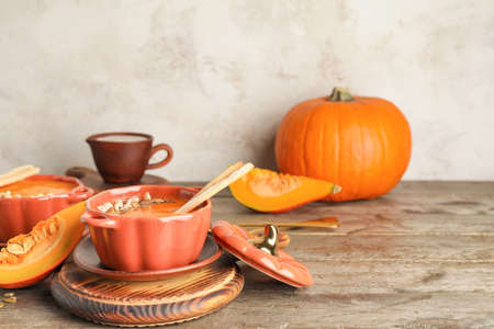 Tasty pumpkin cream soup in pot on tableの写真素材